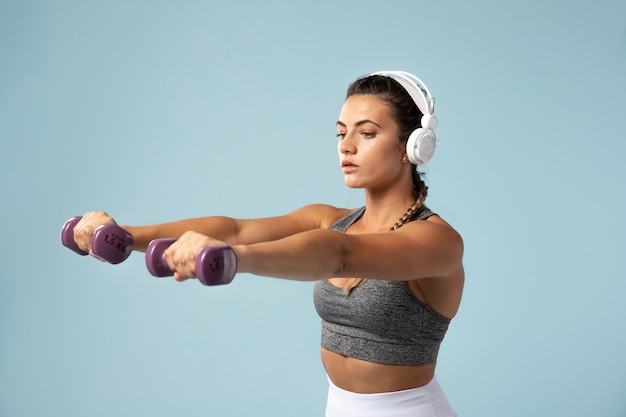 Free photo young woman doing exercises with her headphones on