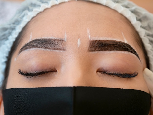 Free photo young woman going through a microblading procedure