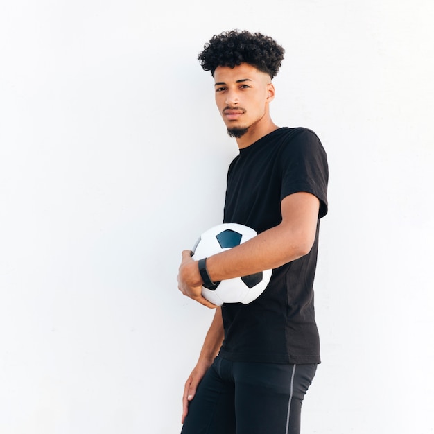 Бесплатное фото Молодой черный человек, нажав футбольный мяч для тела