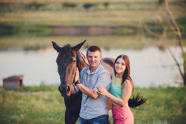 Young couple spending time together with their horse