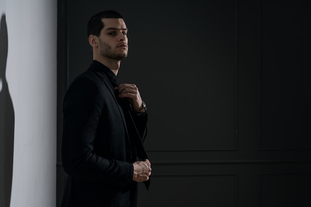 Бесплатное фото Молодой красивый бизнесмен в черной рубашке и черном костюме