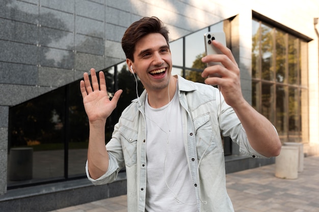 Бесплатное фото Молодой человек с видеозвонком на своем смартфоне