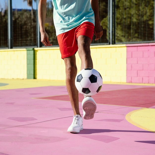 Молодой человек играет в футбол крупным планом