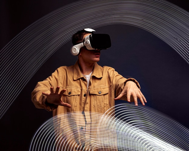 Бесплатное фото Молодой человек в очках виртуальной реальности со спецэффектами вокруг него