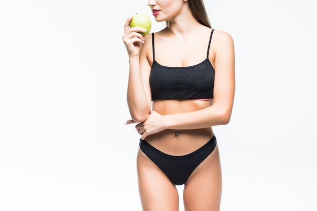 Бесплатное фото Молодая стройная женщина, держащая зеленое яблоко. изолированные на белой стене. концепция здорового питания и контроль избыточного веса.