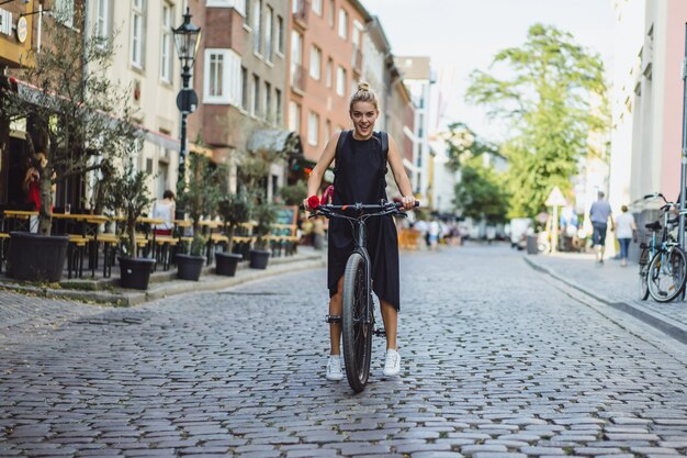 Молодая спортивная женщина на велосипеде в европейском городе. Спорт в городских условиях.