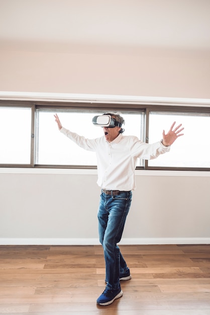 Free photo amazed senior man touching in the air during the vr experience