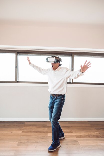 Amazed senior man touching in the air during the vr experience