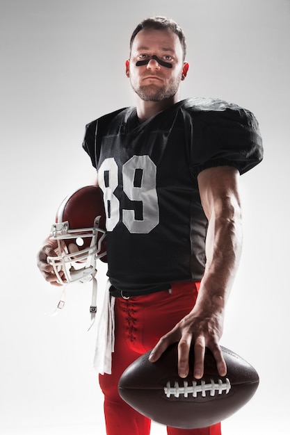 Free photo american football player posing with ball on white
