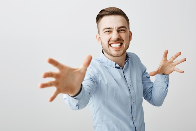 Free photo annoyed businessman look angry reaching hands forward to strangle someone
