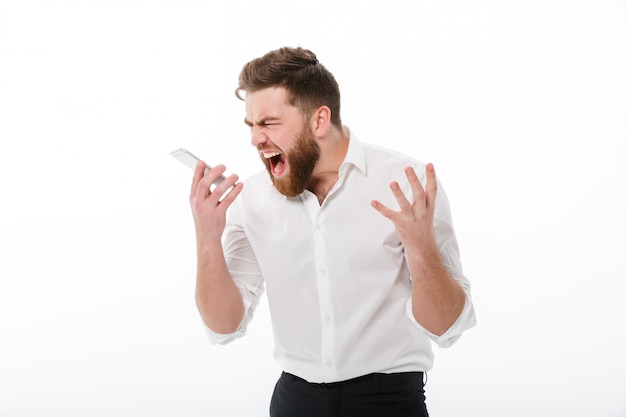 Free photo angry bearded man in business clothes screaming at smartphone