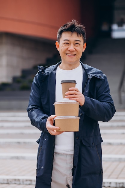無料写真 テイクアウトのフードボックスを持つアジア人の男