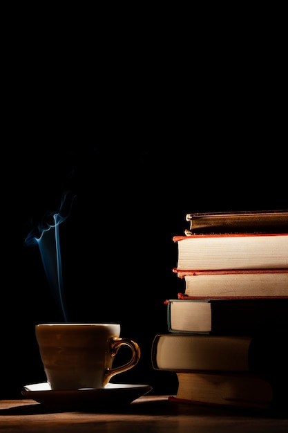Композиция с книгами, чашкой и темным фоном
