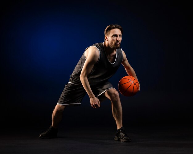 Спортивная (ый) мужчина держит баскетбол