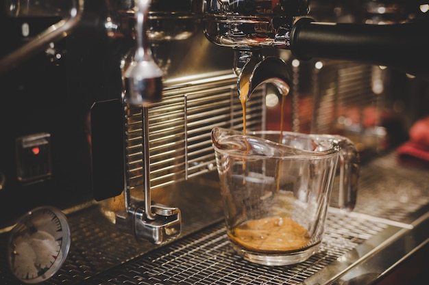 Foto gratuita barista utilizzando la macchina per il caffè nella caffetteria.