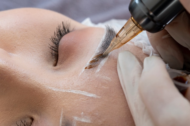 Free photo beautician doing a microblading procedure on a client's eyebrows