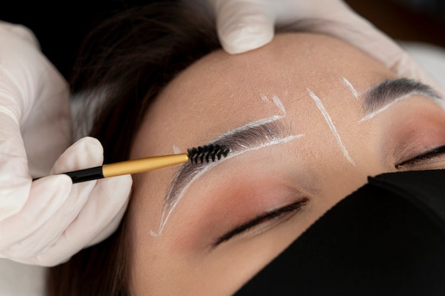 Free photo beautician working on a client's eyebrows