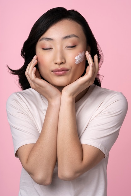 Free photo beautiful asian woman applying makeup