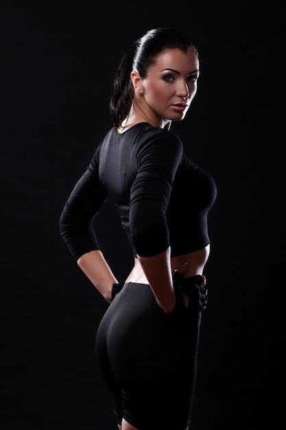 Бесплатное фото Красивая фитнес-девушка на черном фоне