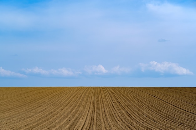 Бесплатное фото Красивый снимок недавно вспаханного фермерского поля на голубом небе