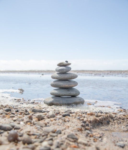 Foto gratuita bello colpo di una pila di rocce sulla spiaggia - concetto di stabilità di affari