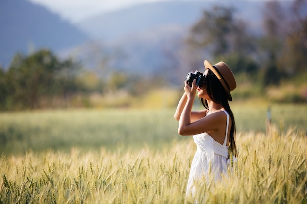 Free photo a beautiful woman who enjoys shooting in barley fields.
