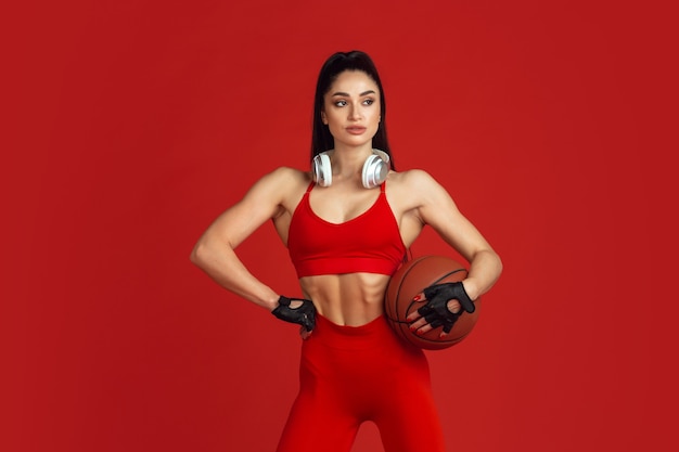 Бесплатное фото Красивая молодая спортсменка, тренирующаяся на красном