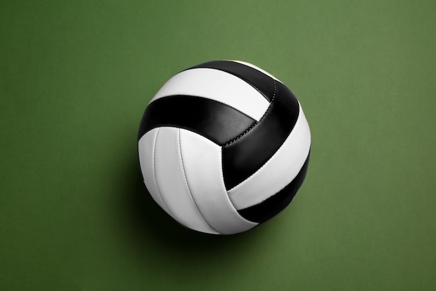 Foto gratuita sfera di pallavolo in bianco e nero brillante. attrezzatura sportiva professionale isolata su sfondo verde studio.