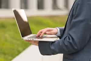 Free photo businessman using laptop outdoors