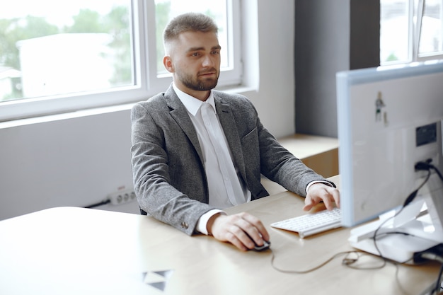 Бесплатное фото Бизнесмен, работающий в офисе. человек использует компьютер. парень сидит в офисе
