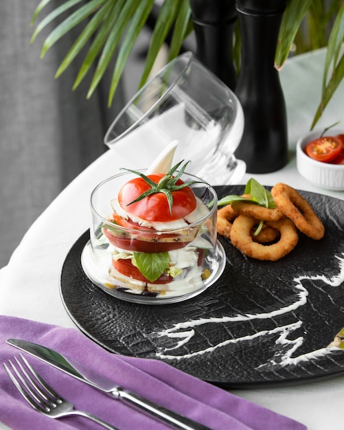caprese salad in glass with onion rings