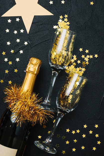 Бесплатное фото Бутылка шампанского с очками на черном столе
