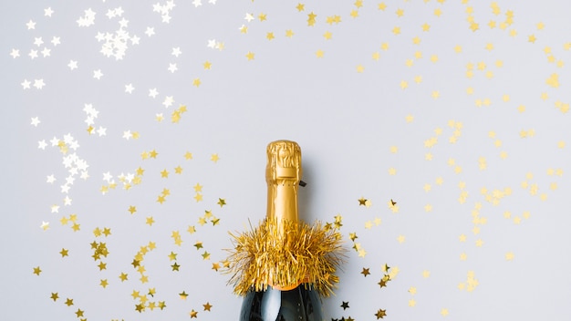 Бесплатное фото Бутылка шампанского со звездообразными блестками