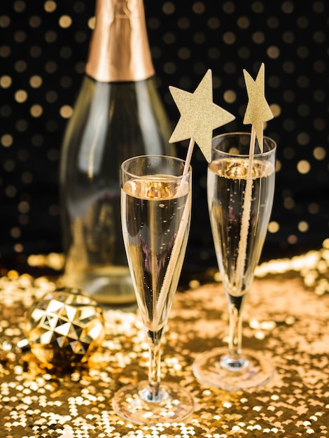 Бесплатное фото Бокалы для шампанского со звездами и золотой тканью
