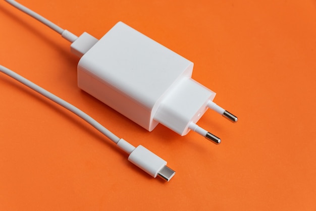 Зарядное устройство и USB-кабель типа C на оранжевом фоне