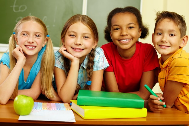 Free photo cheerful schoolchildren with blackboard background
