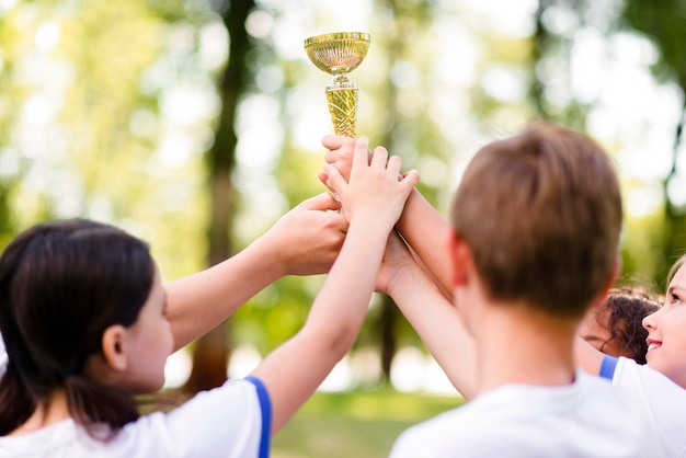 Бесплатное фото Дети держат золотой трофей