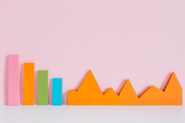 Free photo colorful bar graph and an orange graph on pink background