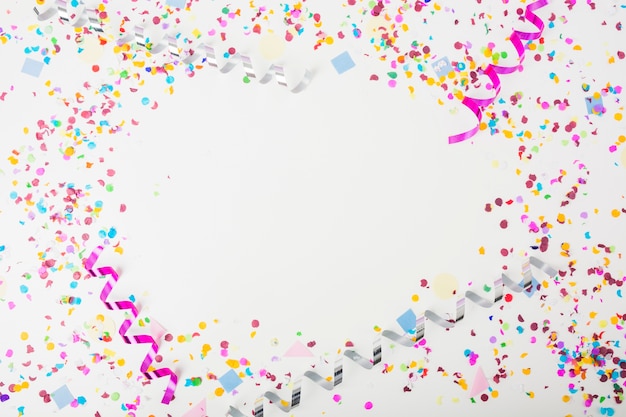 Free photo colorful confetti and curling streamers on white background with space for text