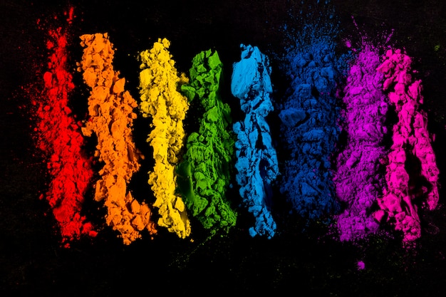 Foto gratuita colori in polvere colorati disposti in fila su sfondo nero