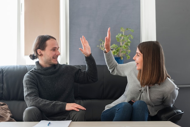 Couple doing high five on couch