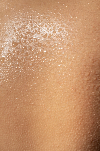 Бесплатное фото Закрыть текстуру увлажненной кожи каплями воды
