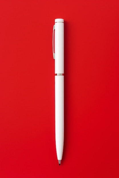 Бесплатное фото Крупный план белой ручки на красном фоне