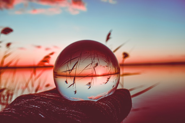 Creative crystal lens ball photography of a lake with tall greenery around