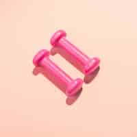 Бесплатное фото Гантели плоские лежали на розовом фоне