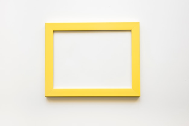 Foto gratuita vista elevata della cornice gialla vuota su sfondo bianco
