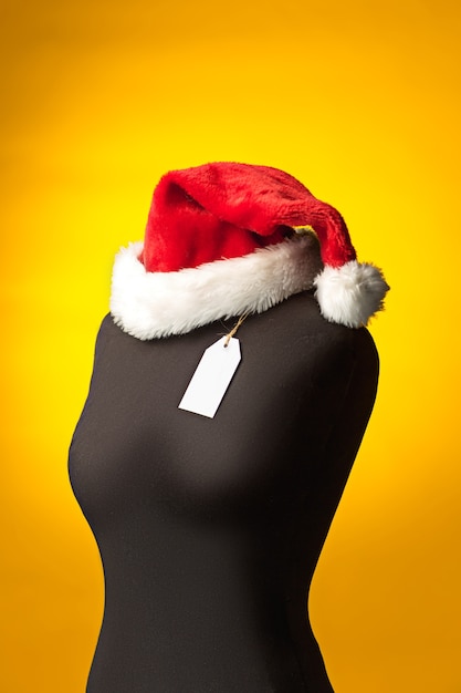 Free photo empty dummy with santa hat, sale price tag hanging from  button hole. shopping and sale concept
