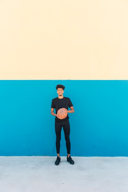 Этнический игрок с баскетболом на улице