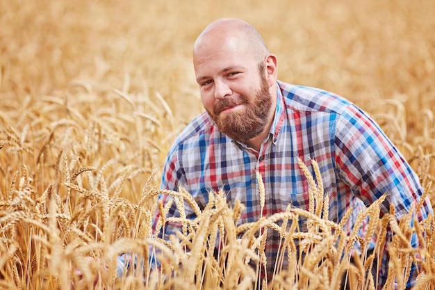 Free photo farmer walking through a wheat field