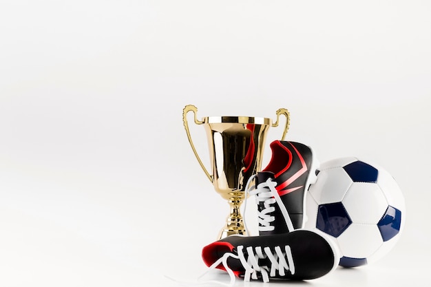 Бесплатное фото Футбольная композиция с мячом для обуви и трофеем